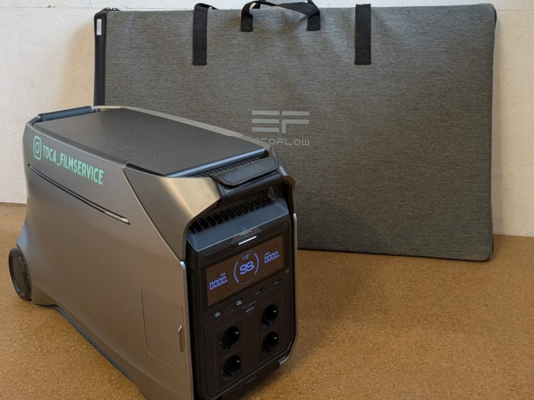 Tragbare Powerstation ECOFLOW DELTA Pro 3 mit Solarpanele im Hintergrund.